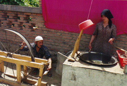Chinese man and wife making silk
